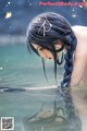 A woman with long black hair is floating in the water.