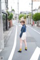 A woman standing in the middle of a street.