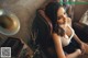 A woman sitting on a brown leather chair next to a gramophone.