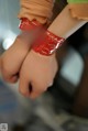 A close up of a person's hand with a red bracelet on it.