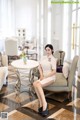 A woman sitting on a chair in a hotel lobby.