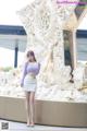 A woman standing in front of a white sculpture.