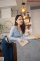 A woman leaning on a counter in a kitchen.