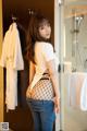 A woman in fishnet stockings standing in a bathroom.