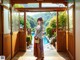 A woman in a kimono standing in front of a door.