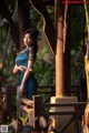 A woman in a blue dress standing on a wooden bridge.