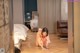 A woman in a kimono cleaning the floor in a hotel room.