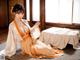 A woman in a kimono sitting on the floor in a room.