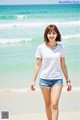 A woman walking on a beach next to the ocean.