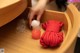 A person putting a red rope in a wooden box.