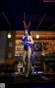 A woman in a bunny costume standing in front of a bar.