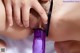 A man is holding a purple dildo in his mouth.