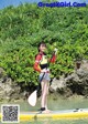 A woman standing on a paddle board in the water.