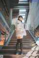 A woman standing on a set of stairs in a building.