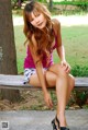 A woman sitting on a bench in a park.