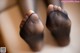 A close up of a person's feet in black stockings.