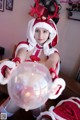 A woman dressed as a santa claus holding a crystal ball.