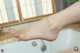 A woman's feet in a bathtub with water coming out of it.