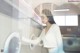 A woman standing in front of a washing machine.