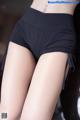 A close up of a woman wearing a pair of black shorts.