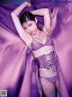 A woman in a purple lingerie posing for a picture.