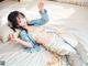 A woman laying on top of a bed in a blue and white outfit.