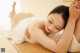 A woman laying on top of a wooden table.